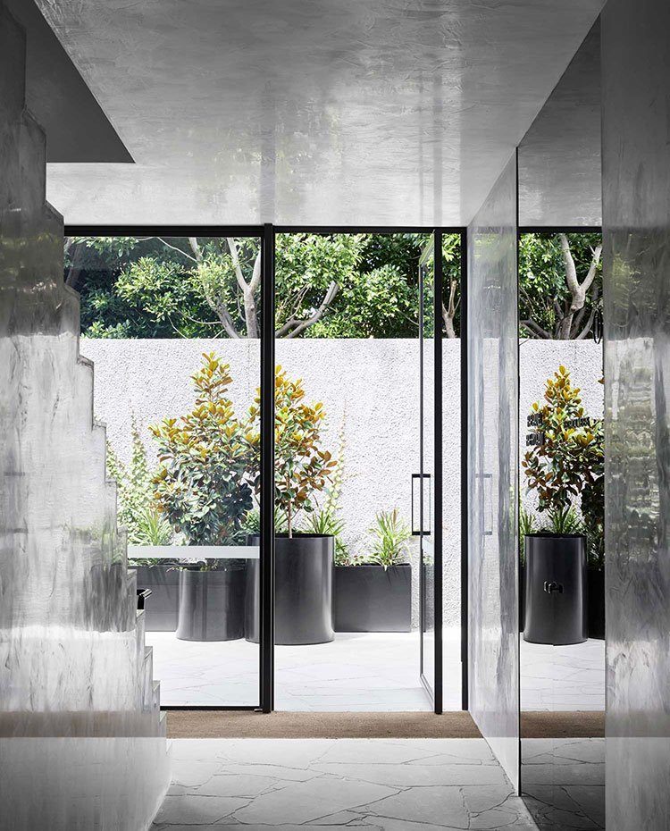 Puerta de entrada con cerramiento de cristal transparente