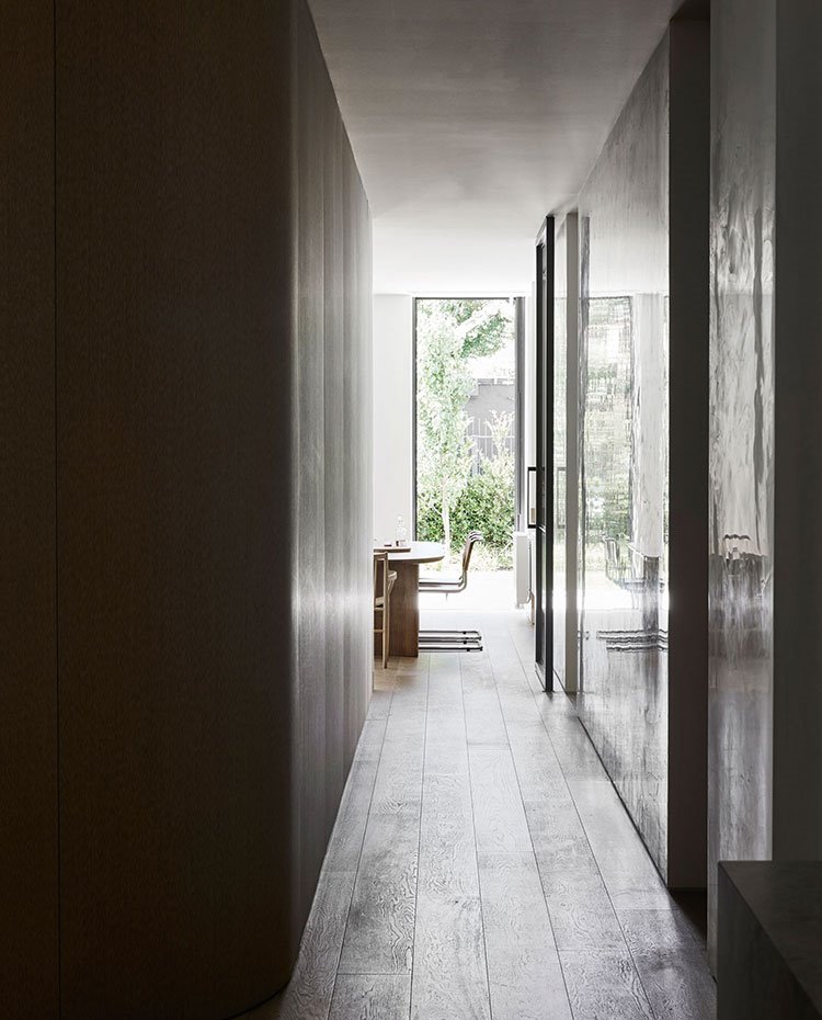 Zona de paso hacia comedor, con suelo de madera y apertura final al exterior