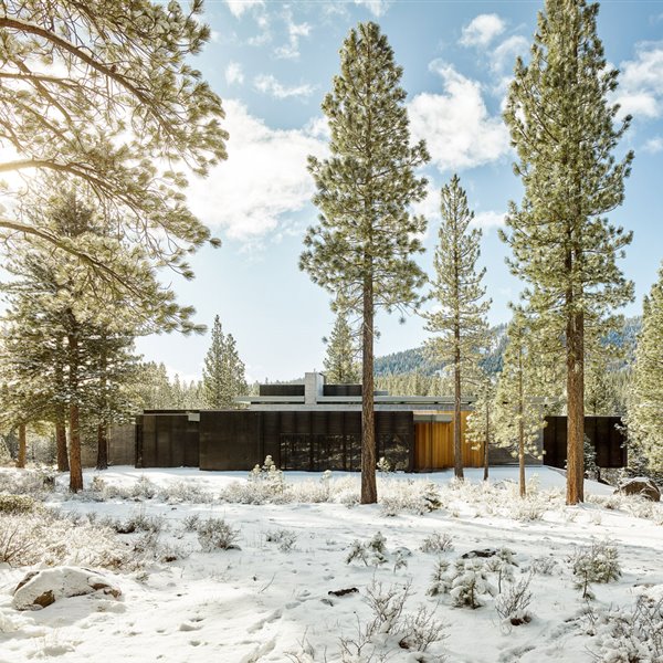 Una impresionante casa entre nieve y rocas volcánicas