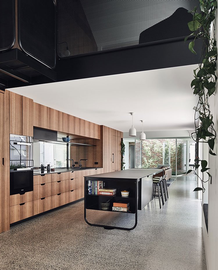 Cocina abierta en madera con tiradores integrados, isla de trabajo en negro