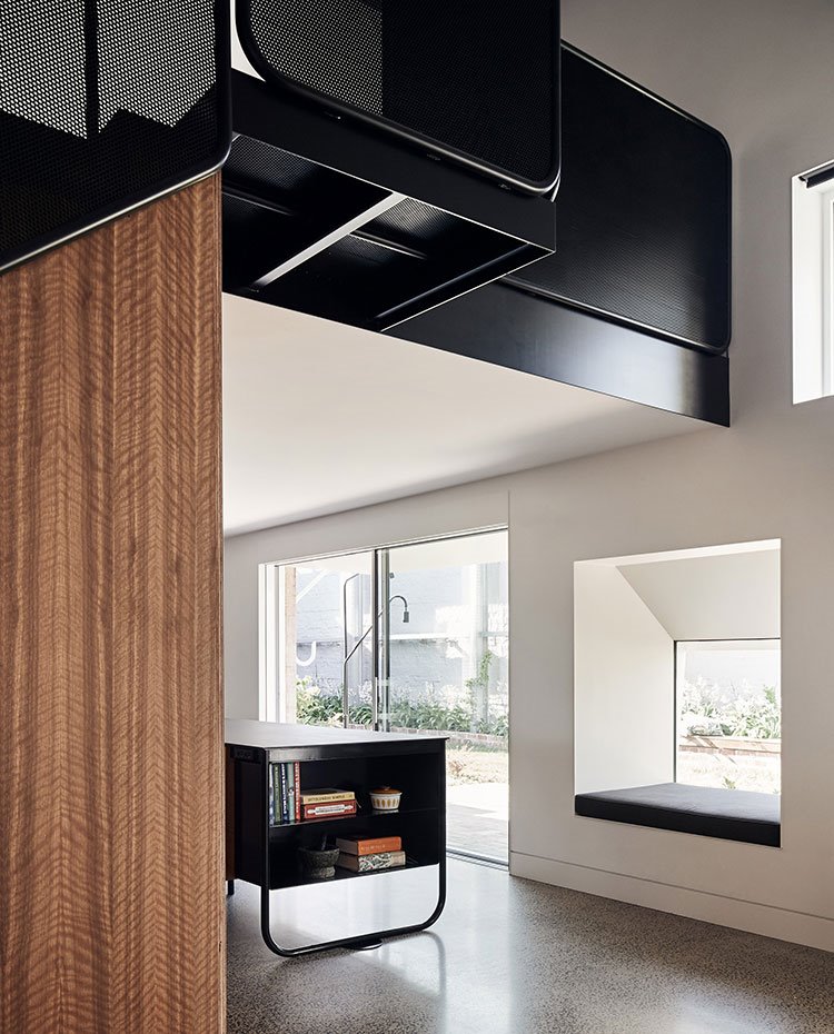 Detalle de isla de cocina, con hueco en fachada sobresalido y zona de paso elevado con estructura en negro