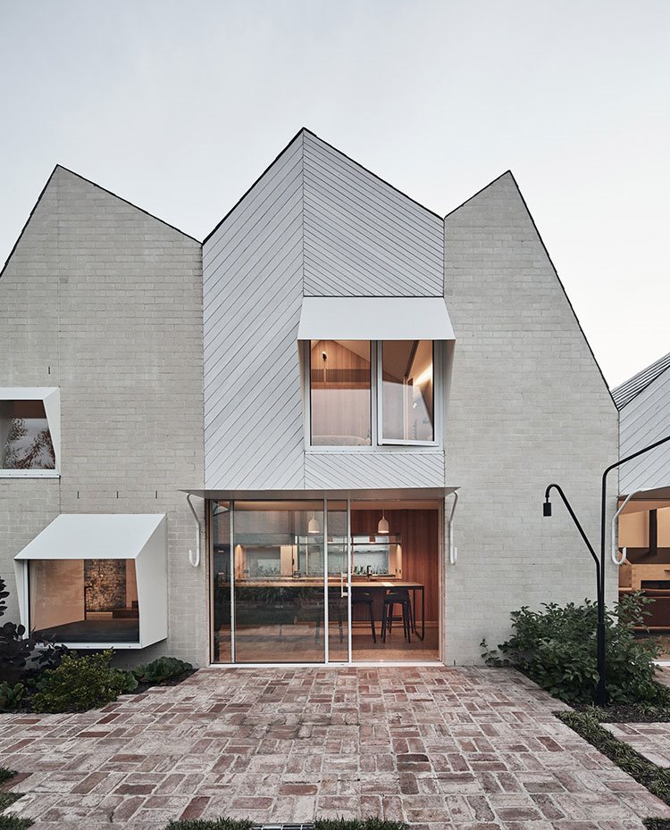 Fachada con ventanas a varios niveles y paso contínuo entre interior-exterior