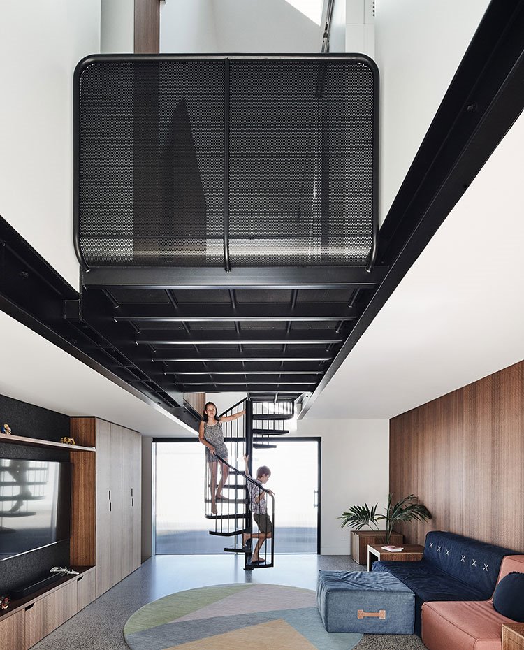 Plataforma superior negra con estructura perforada entre vigas negras, escalera de caracol