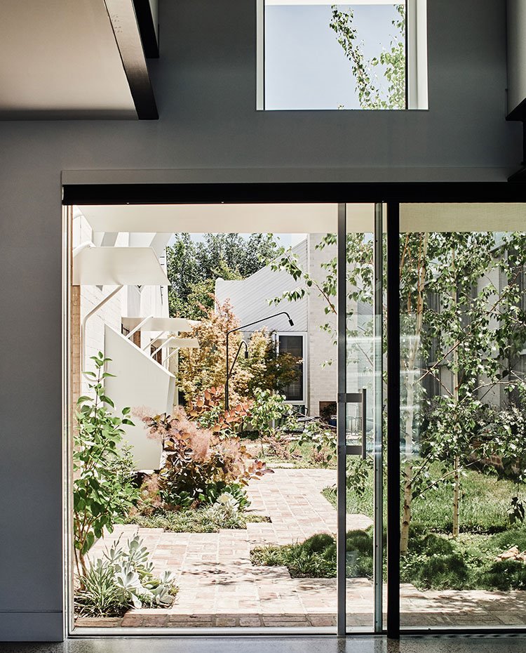Puertas correderas hacia jardín, perfilería de aluminio y doble altura con ventana superior