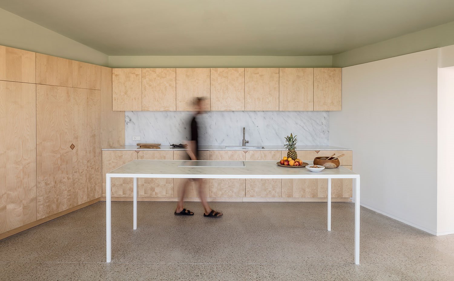 Cocina con isla de trabajo minimalista y mobiliario en madera