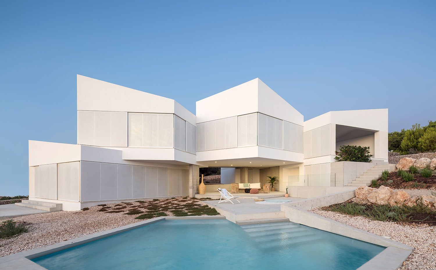 Exterior vivienda en blanco frente a piscina de formas geométricas