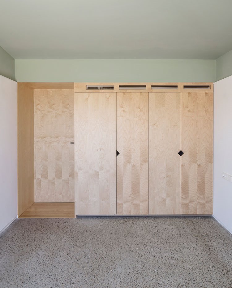 Interior habitación con armarios a medida, suelo de granito y cubierta pintada en verde