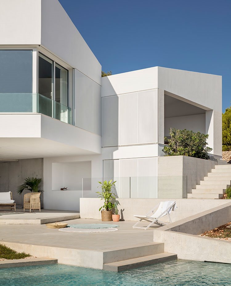Terraza junto a piscina con exteriori de vivienda en blanco