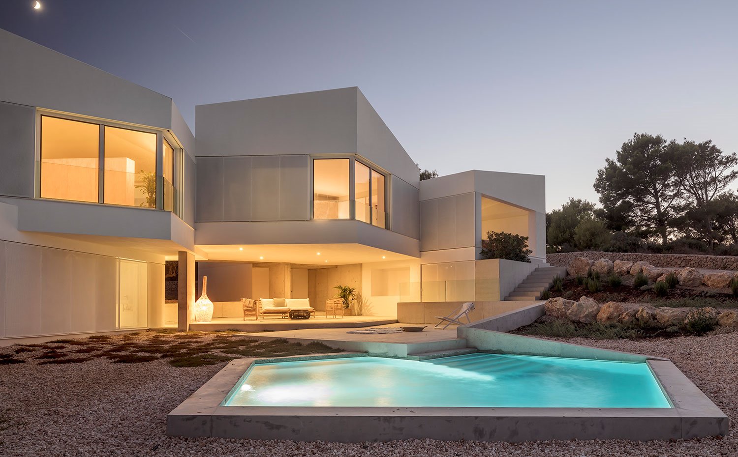 Vista al atardecer de la vivienda con iluminación de la casa