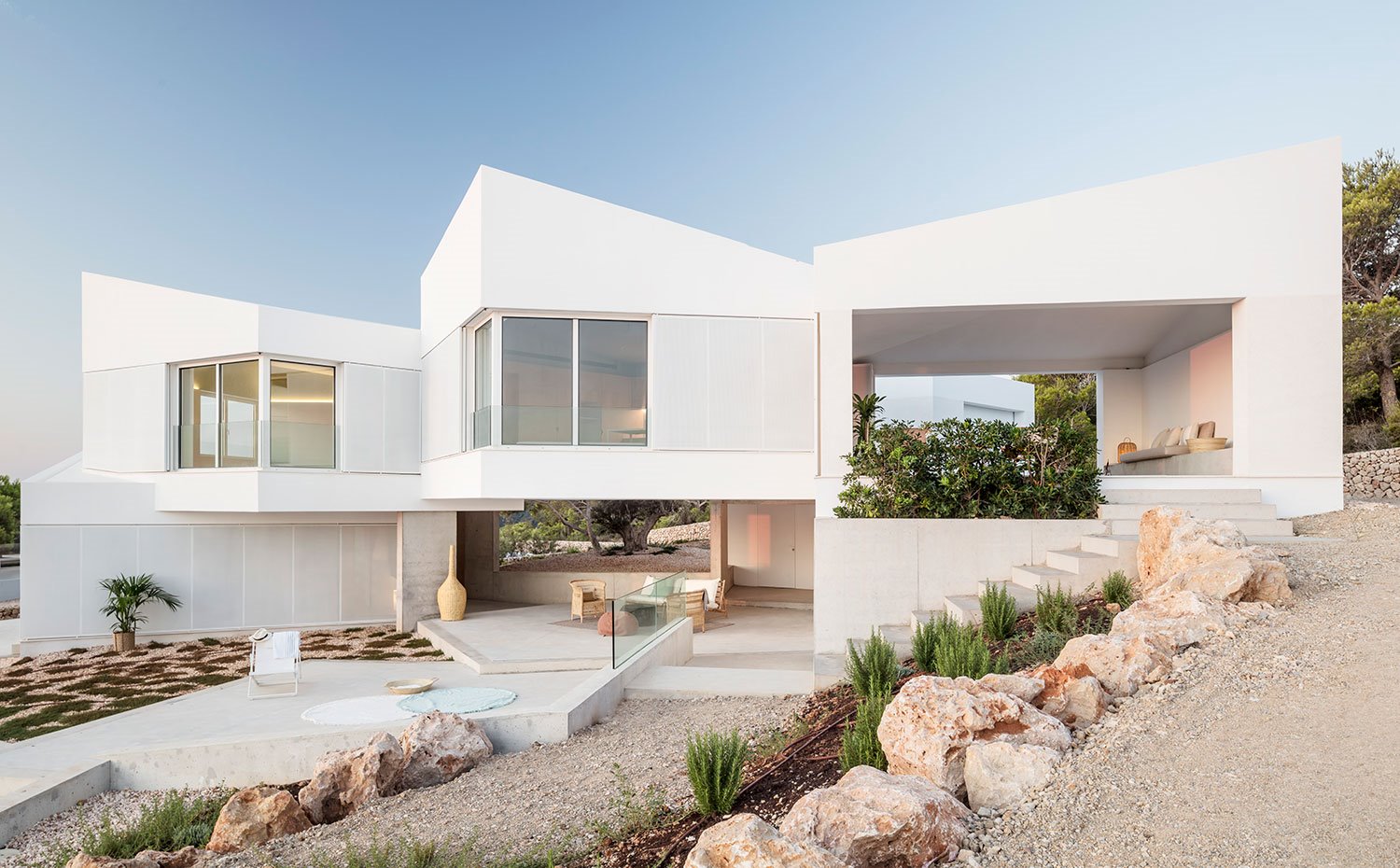 Vista de los diferentes niveles de la vivienda desde el exterior con camino de tierra 
