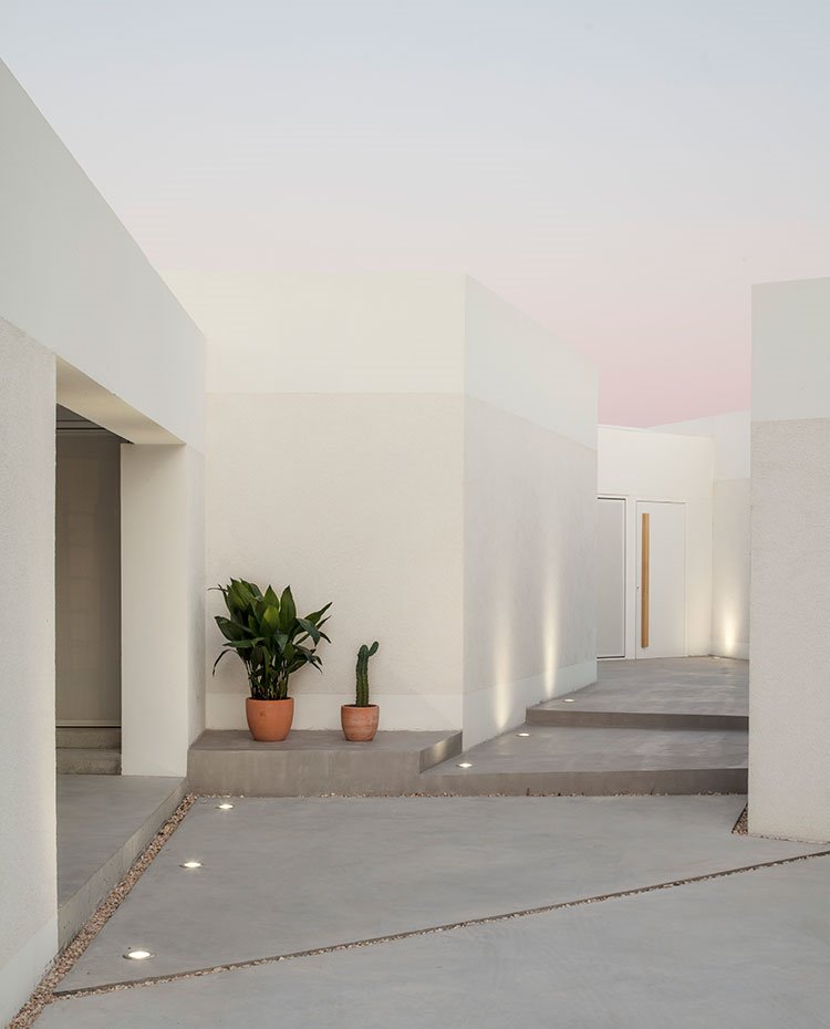 Zona de acceso a la vivienda con estructura de hormigón e iluminación empotrada