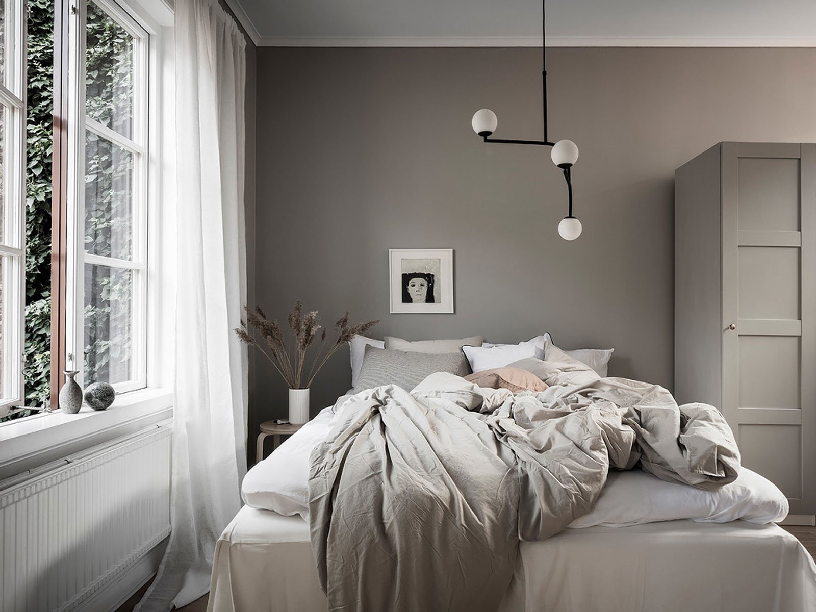 Dormitorio con ventana y ropa de cama gris