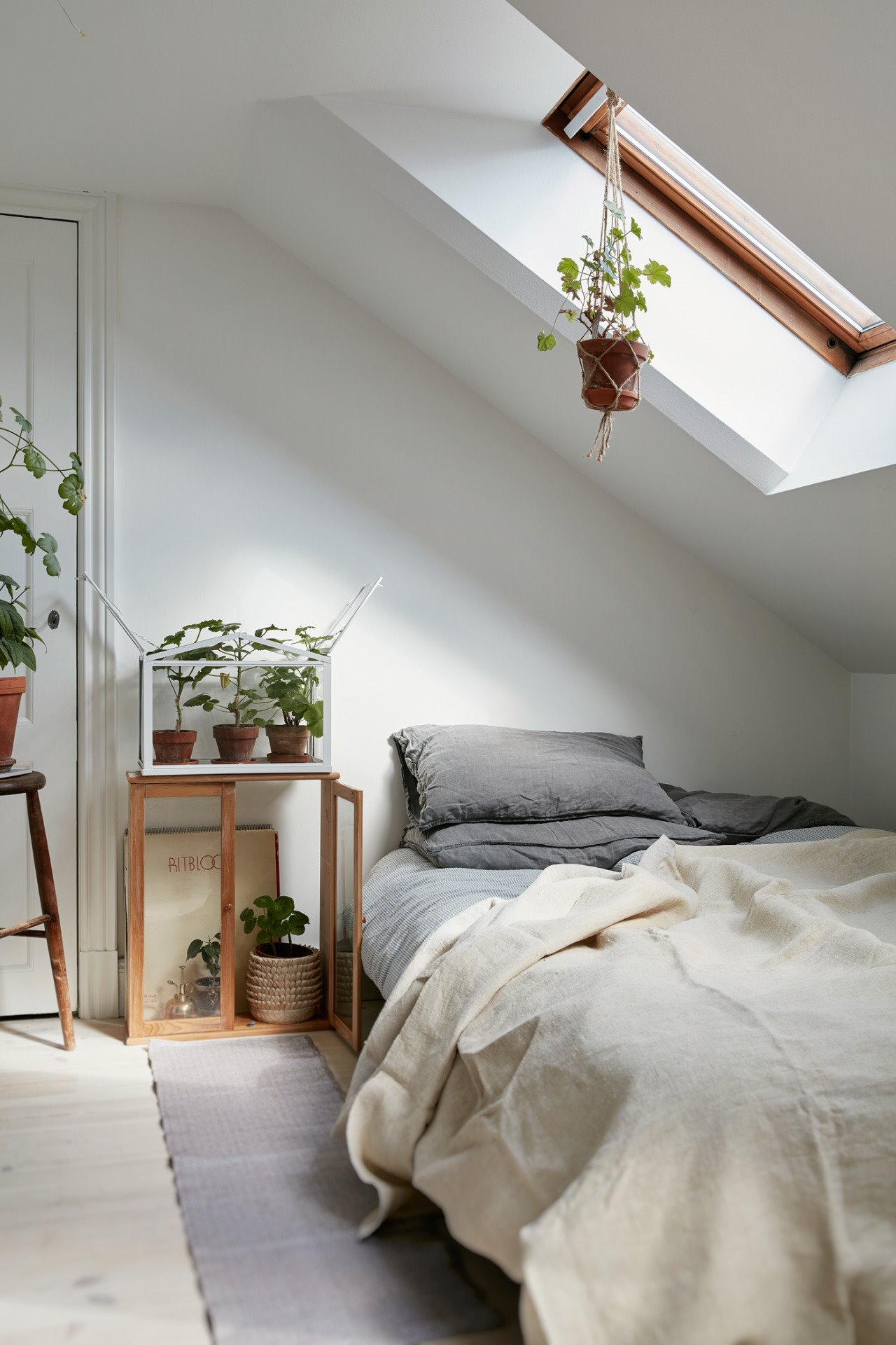 Dormitorio en buhardilla con ventana en el techo