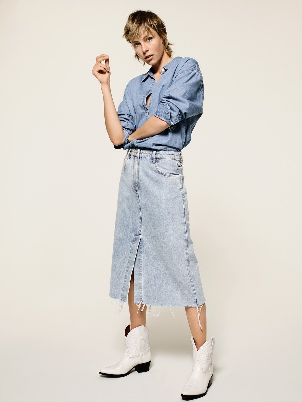 El denim sobre denim puede ser una ecuación recurrente en los outfits diarios. Falda y camisa vaqueras combinadas con unas atrevidas botas cowboy blancas.