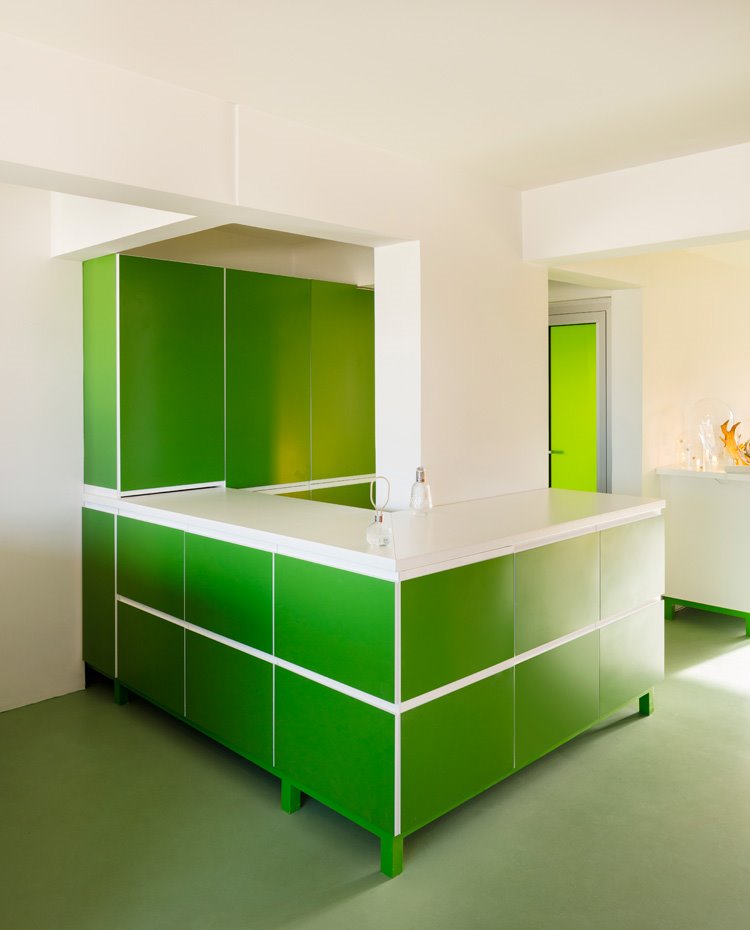 Zona de almacenaje en verde, encimera en blanco, cristal de puerta en verde