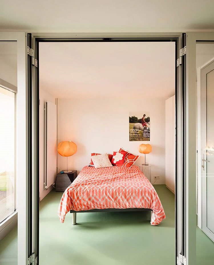 Entrada hacia dormitorio con cerramientos de cristal y aluminio, suelo contínuo verde