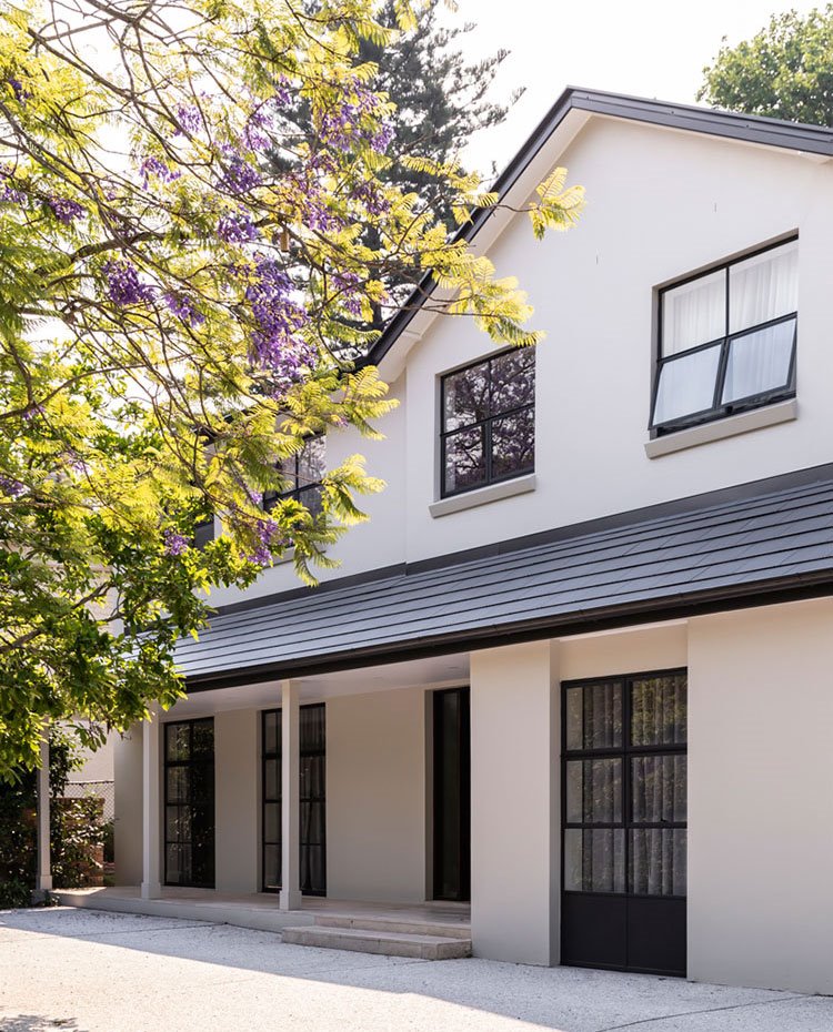 Exterior vivienda de doble nivel con fachada en blanco y cubierta y cerramientos en negro