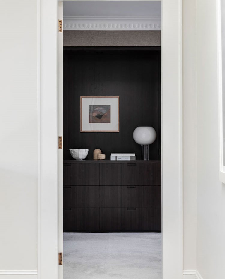 Puerta con acceso a dormitorio con carpintería de madera oscura, moldura en el techo y suelo de mármol blanco