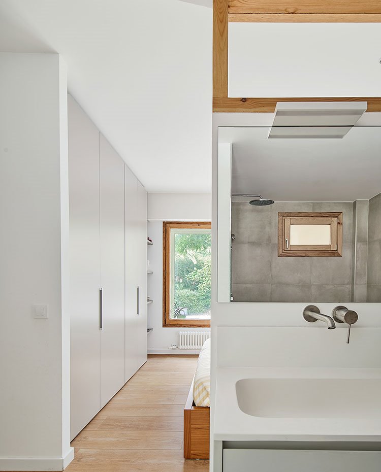 Lavamanos cuarto de baño junto a zona de paso hacia dormitorio con frente de armaios de suelo a techo