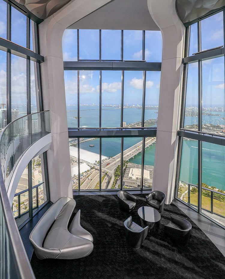 Interior sala de estar con cristalera a doble altura con panorámicas de Miami
