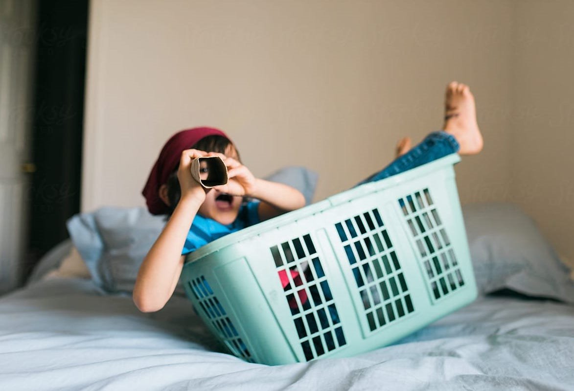 NIño dentro de una cesta de ropa