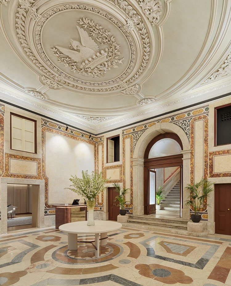 Vestíbulo del hotel de grandes techos tallados, suelo y paredes revestidas de mármol con motivos geométricos
