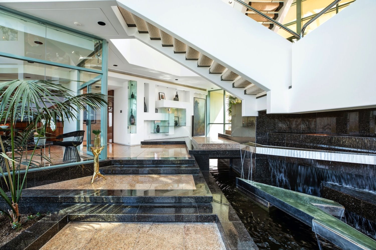 En el interior, los tragaluces piramidales y las líneas irregulares mantienen la misma estética. Los espacios comunes tipo atrio incluyen un vestíbulo con una piscina decorativa.