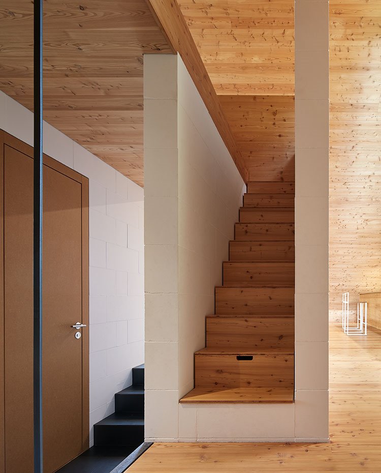 Escaleras con zona de almacenamiento hacia buhardilla revestidas de madera