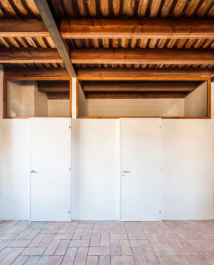 Paredes y puertas de dormitorios a media altura con parte superior con cerramiento de cristal y marco de madera, cibierta de madera