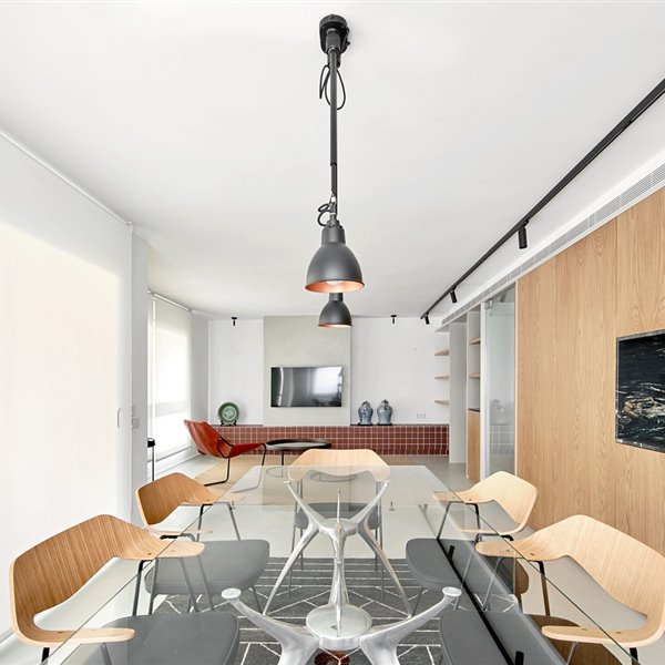 Comedor con iluminación suspendida, con estores enrollables frente a ventanas