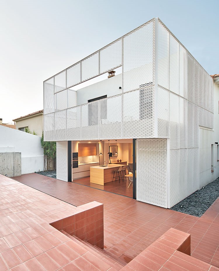 Escaleras de patio exterior que comunica la piscina con la vivienda, perímetro de la casa con piedras de pizarra, fachada en blanco