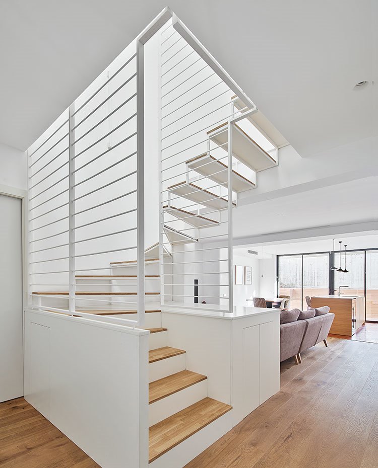 Hueco de escalera junto a salón, con estructura metalizada a base de rejas horizontales