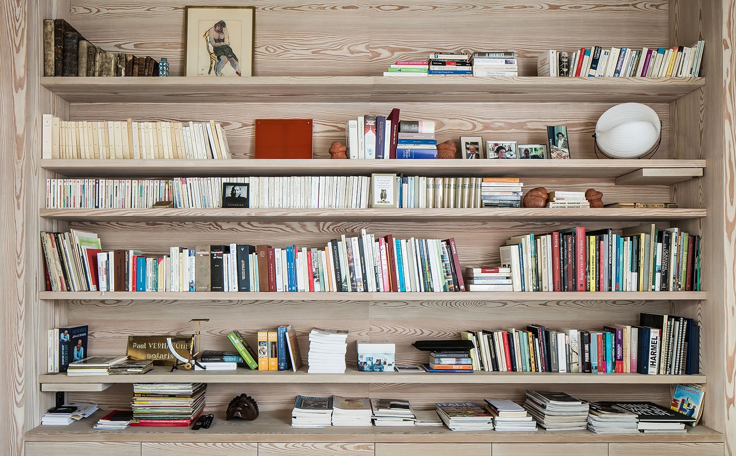 Librería repleta de libros, sobre estructura de carpintería hecha a medida en madera veteada.
