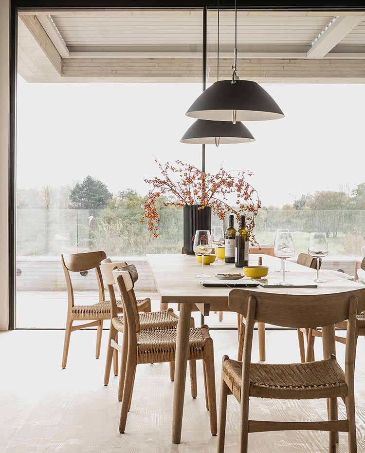 Mesa comedor y sillas de madera, luminarias suspendidas negras