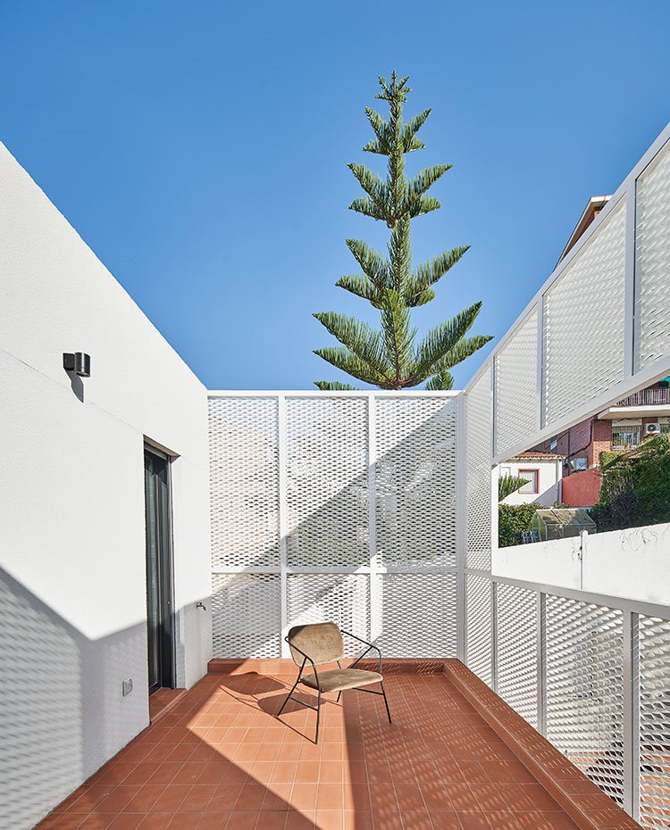 Terraza piso superior con estructura de la casa en blanco y cerramiento en estructura metalizada