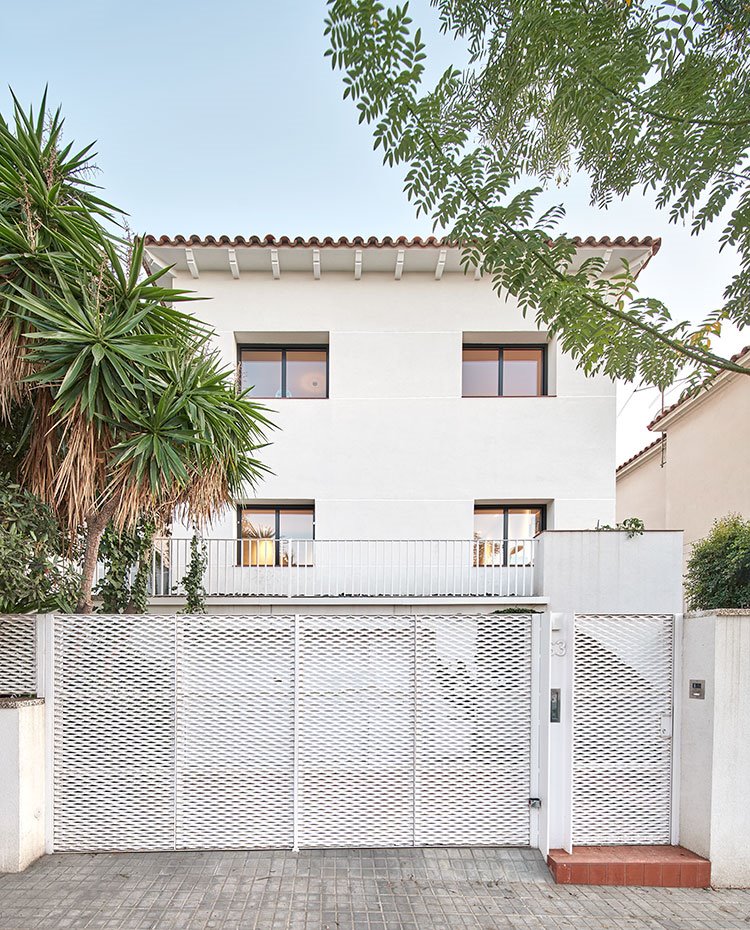 Valla de entrada a la vivienda en blanco, vista desde la calle de la construcción tradicional