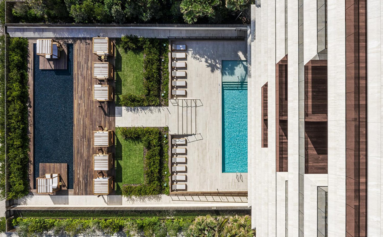 Vista cenital de los balcones, con suelo de madera, y de la zona comuniatria de piscina y jardines