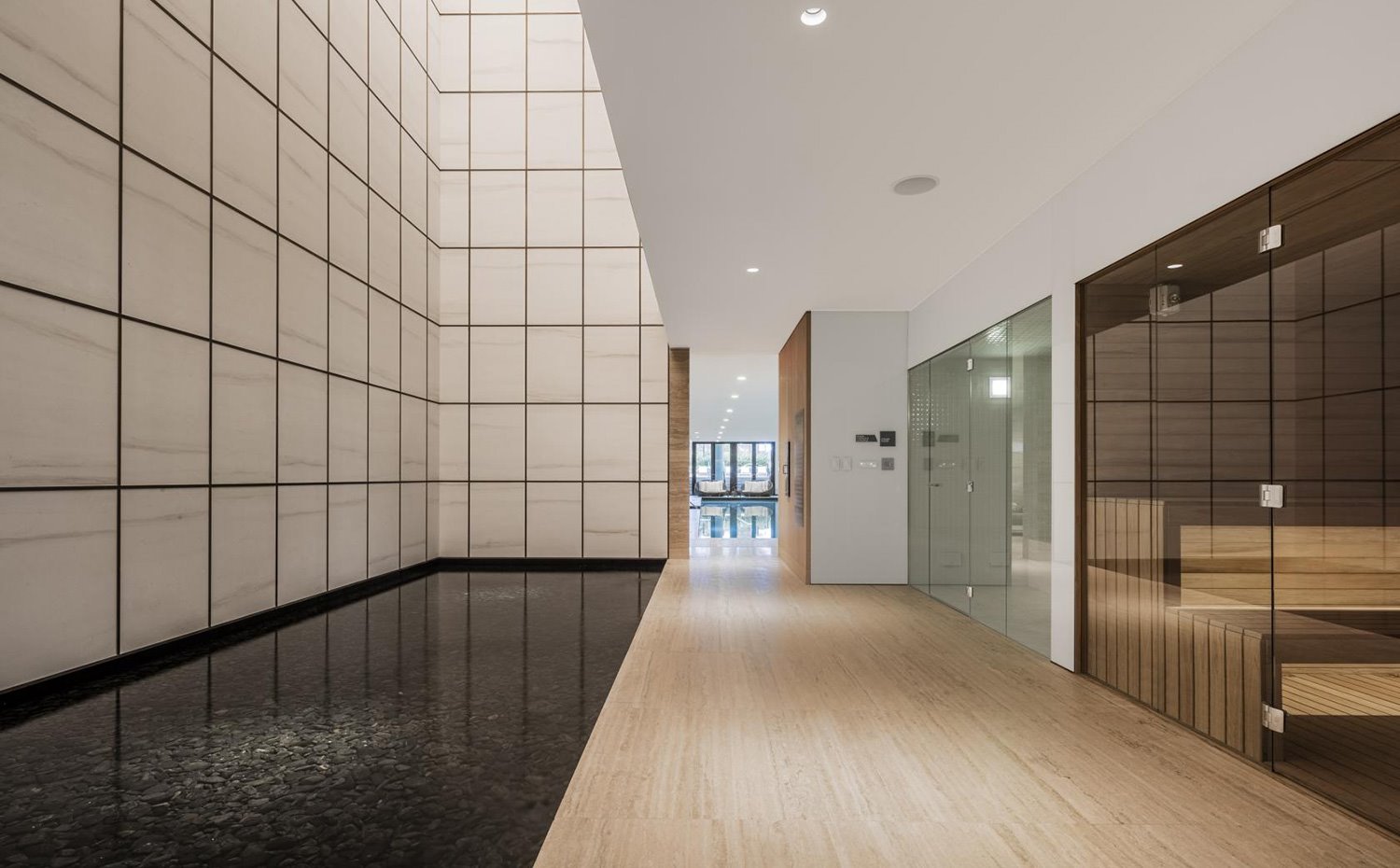 Zona de vestíbulo con suelo de madera y patio de luces con agua estancada en la base