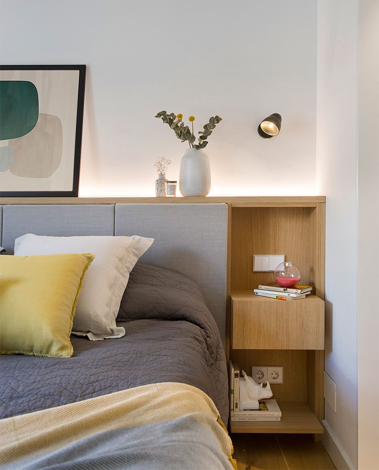 Detallo cabecera de cama con mesilla de noche en estructura de madera natural, aplique en pared