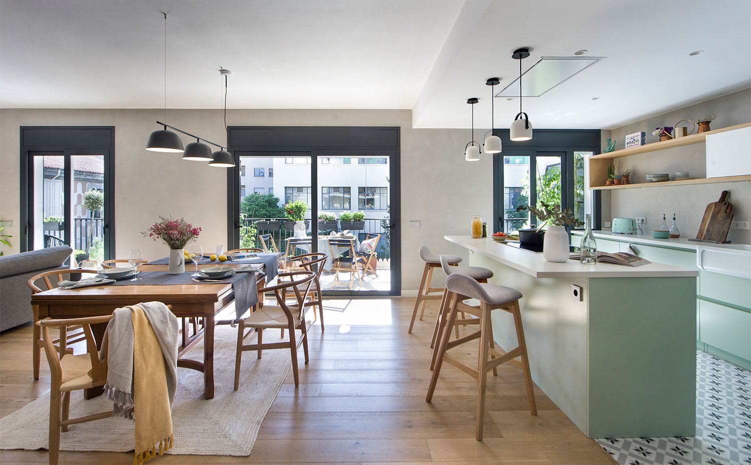 Zona de día con cocina abierta y comedor con vista al balcón exterior