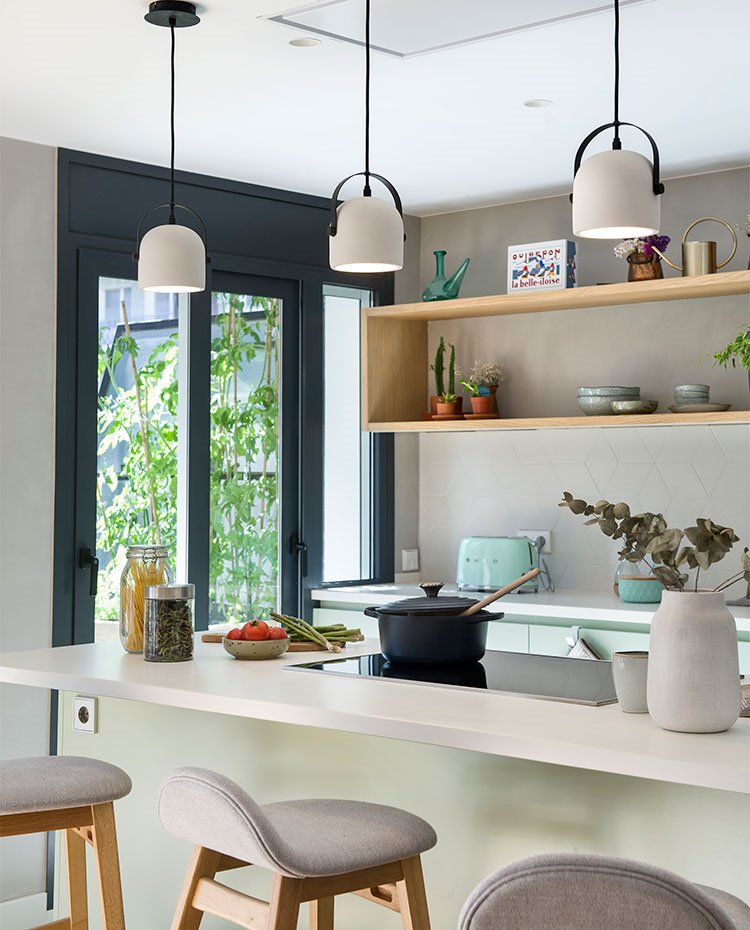 Zona de office en cocina con encimera en voladizo y taburetes de madera tapizados en gris