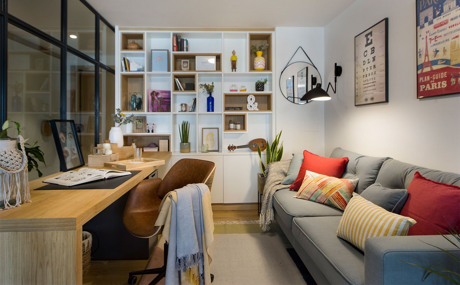 Zona de trabajo con sofá en gris, mesa de madera y estantería en blanco