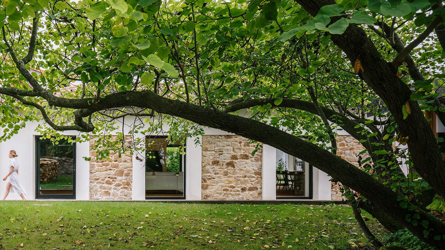 jardin-arboles-ventanas-y-pared-de-piedra-en-casa-en-Guemes Cantabria