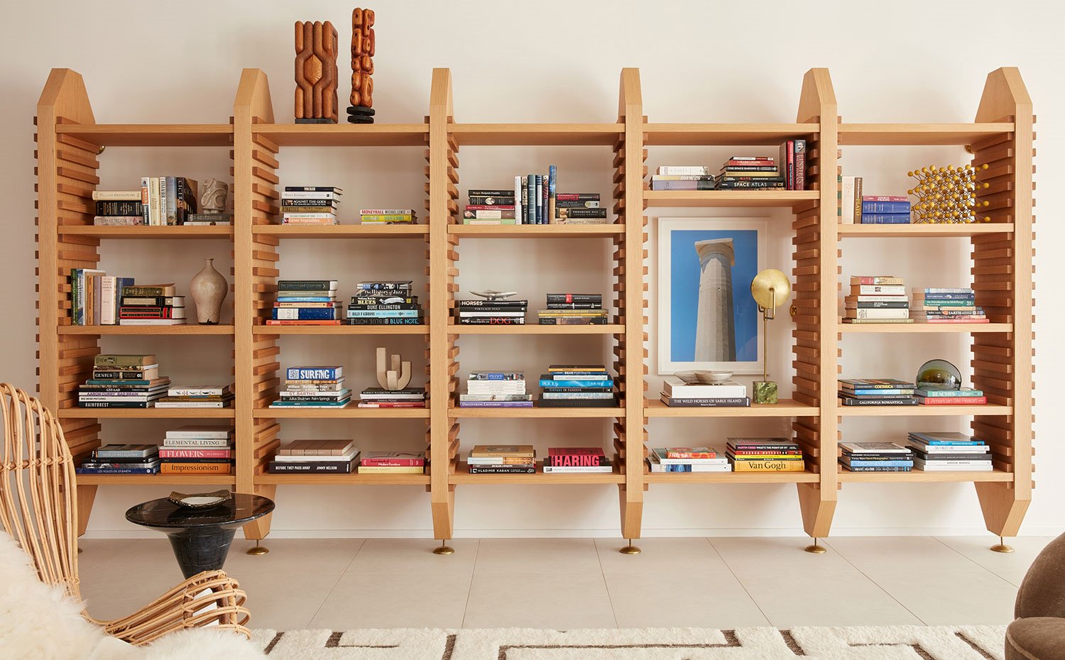 Librería modular en madera, asiento de fibra antural, mesa auxiliar circular en negro
