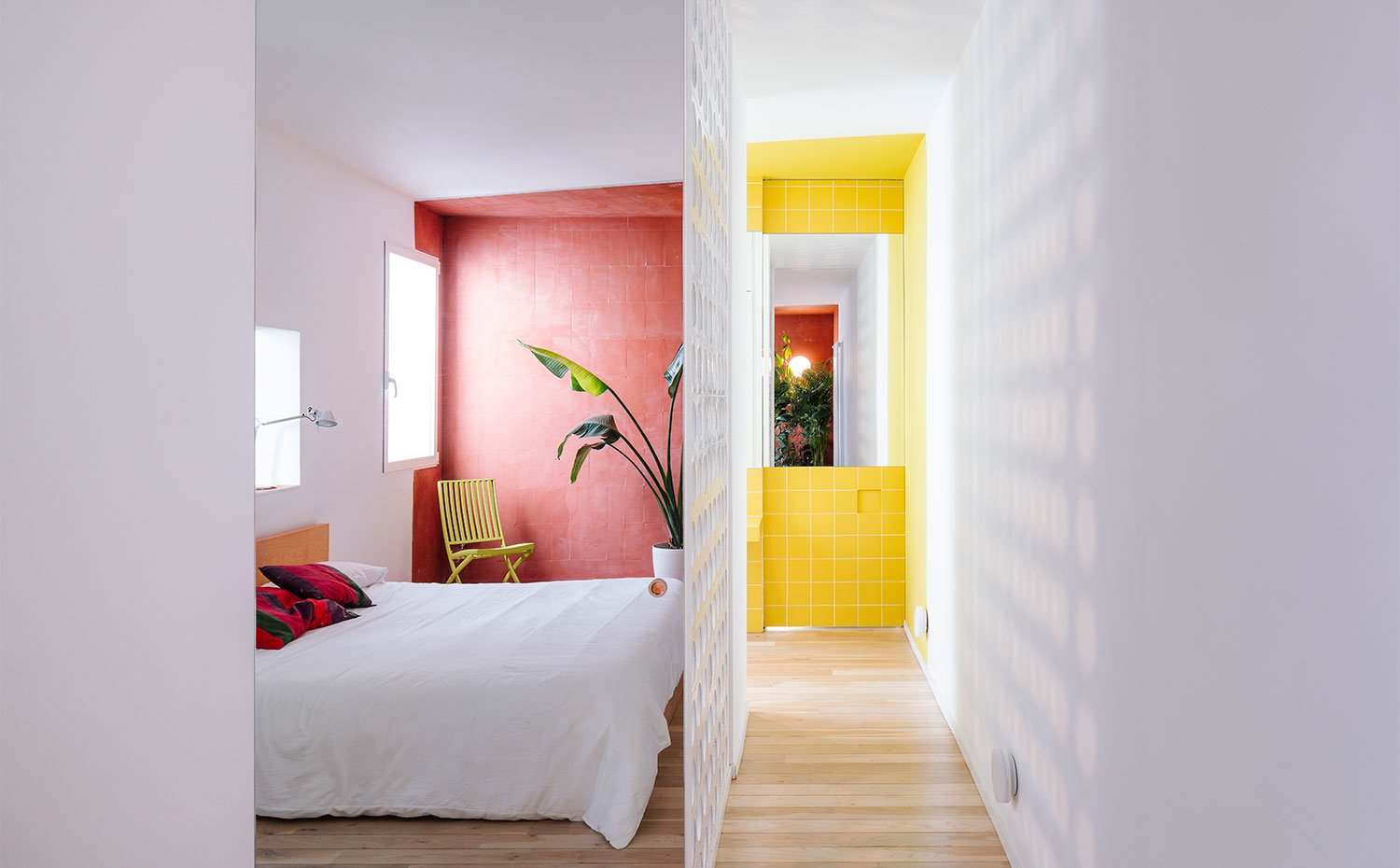 Vista de dormitorio con panel perforado, zona de acceso a cuarto de baño revestido de amarillo