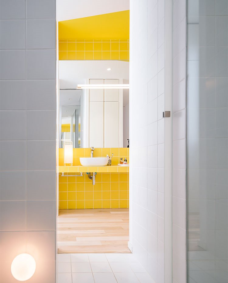 Zona ducha en blanco, aplique circular en pared, zona tocador en amarillo