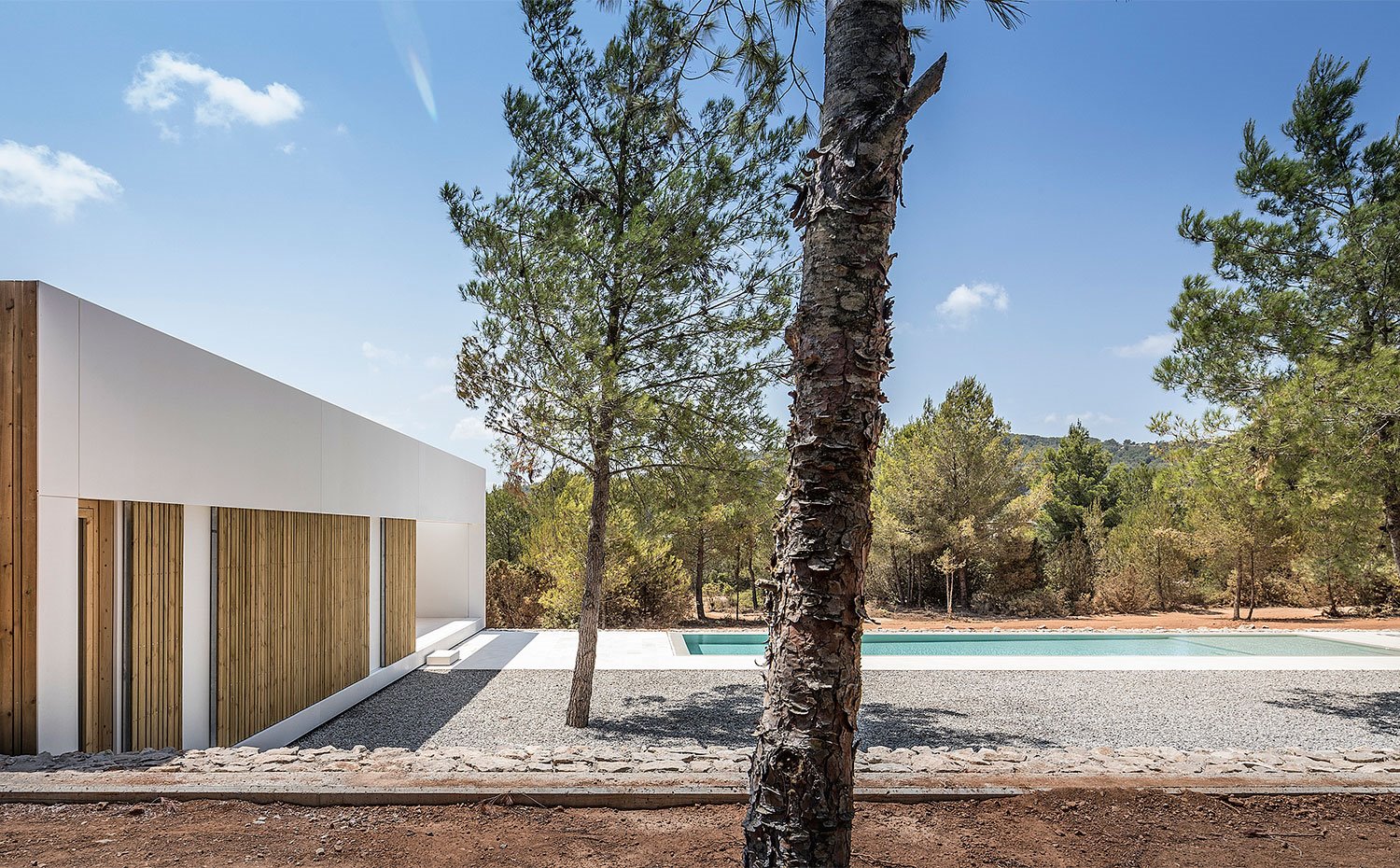 Lateral piscina con módulo en blanco con cerramientos de madera