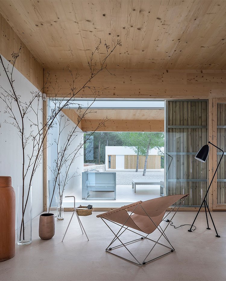 zona de estar interior con techo de madera y cerramientos de cristal