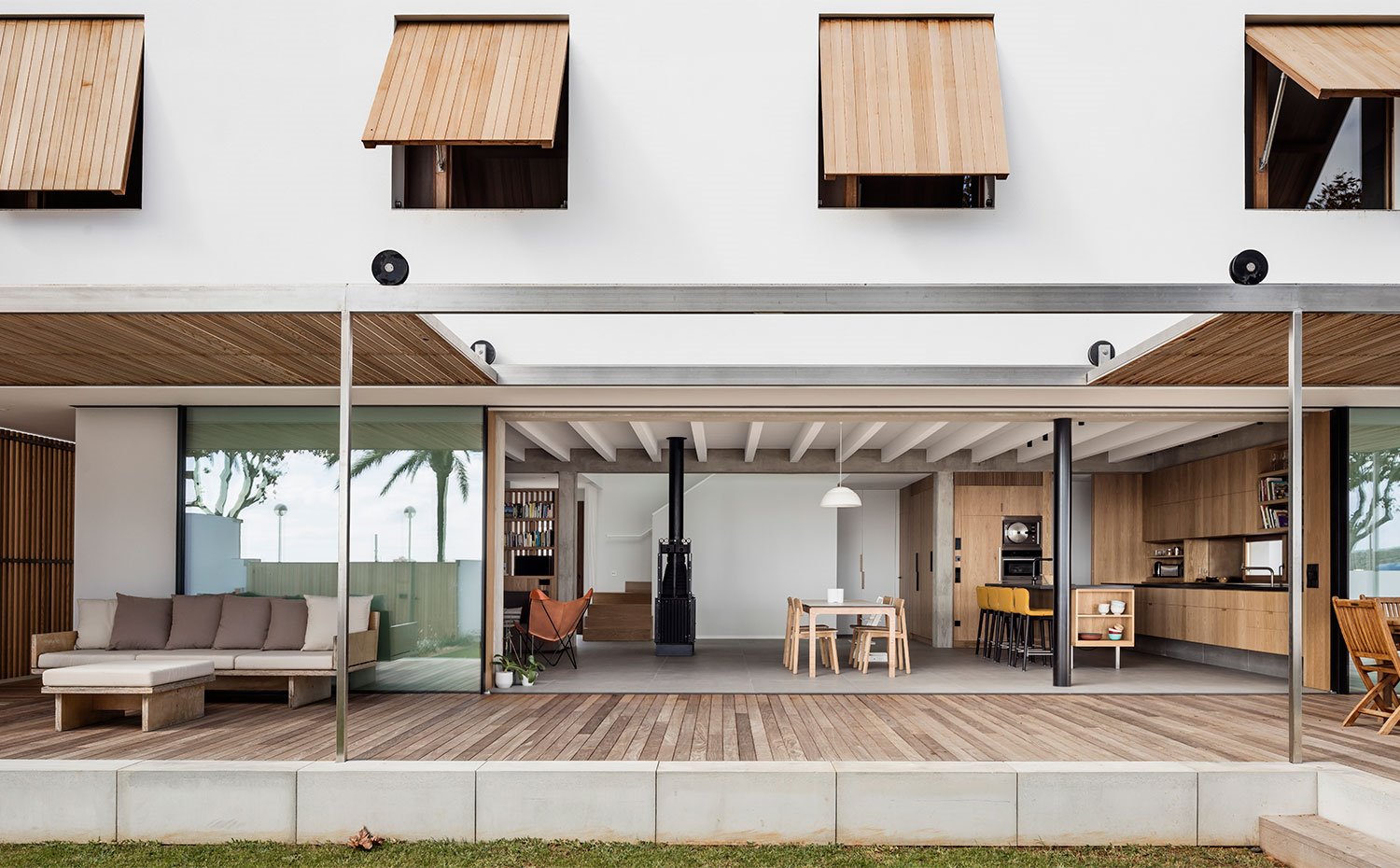 Porche cubierto con suelo y techo  de laminado de madera, cerramientos de ventanas en madera abatible, correderas hacia interior