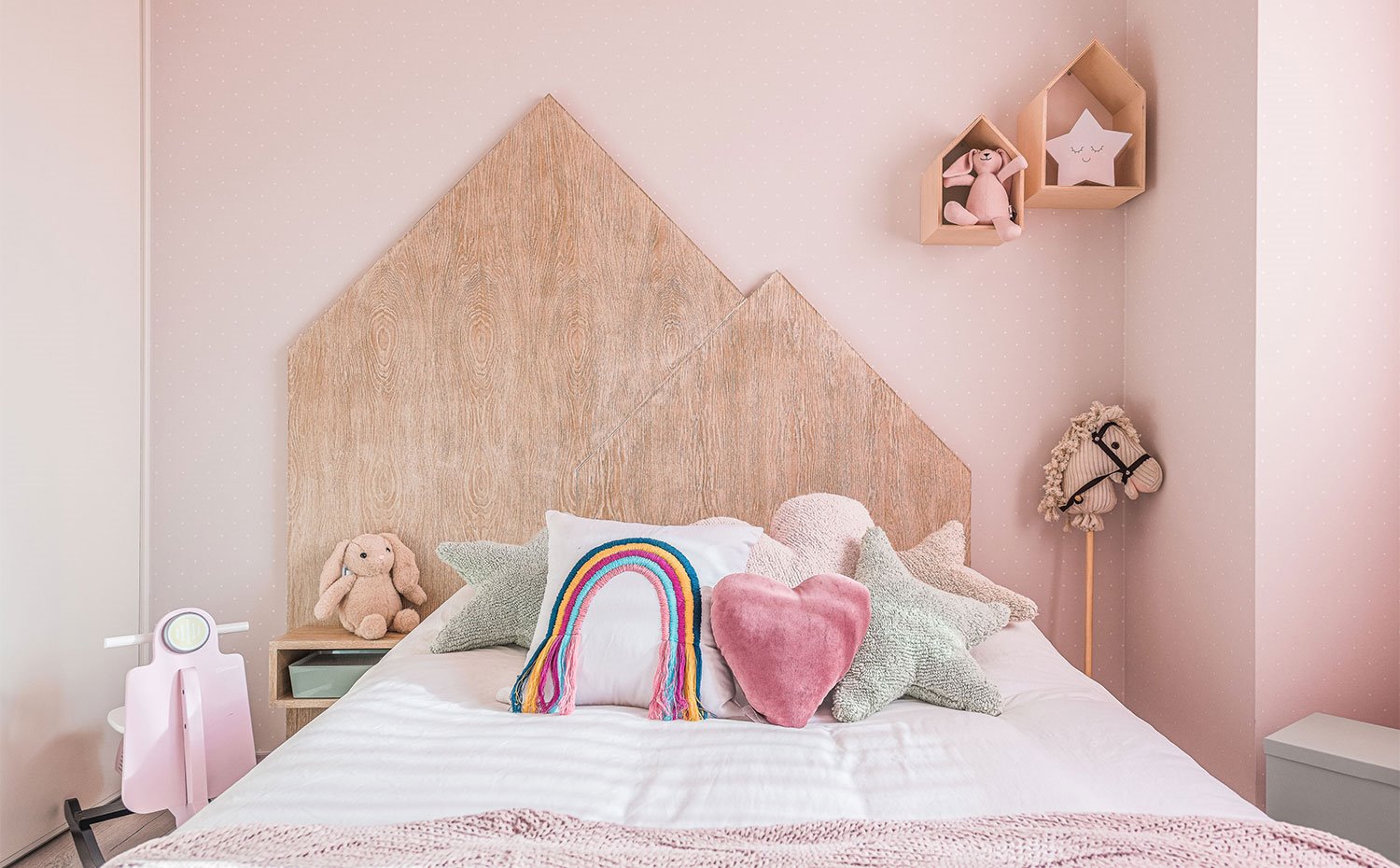 Dormitorio infantil con paredes en rosa y cabecero con forma de casa